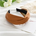 Detail of a brown leather cross headband featuring a unique twisted knot and matte texture - Twisted Brown