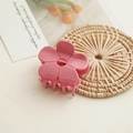 Close-up of pink flower hair claw clip with glossy finish on a cream background - Pink