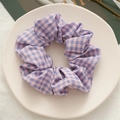 Detailed texture of pink and purple plaid fabric scrunchie on a white ceramic tray - Deep Purple Plaid