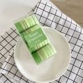 Detail of gradient green elastic hair ties set in a transparent rectangular storage box - Green