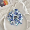 Close-up of floral scrunchie with blue blossoms on white fabric in ceramic tray - Large Blue Flower
