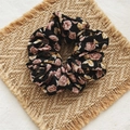 Vintage black floral scrunchie with pink rose patterns on a woven mat background - Black Rose
