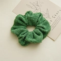Detailed texture of green tweed scrunchie with metallic silver threads for bun styling - Green