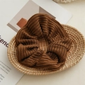 Detail of deep brown knitted scrunchie with soft yarn texture on a rustic tray - Brown