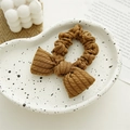 Detail of caramel brown knitted bow scrunchie with soft ribbed texture on ceramic tray - Dark Coffee