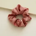 Close-up of pink satin scrunchie with soft silk texture and elegant pleated design - Satin Pink