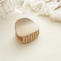 Macro shot of minimalist matte beige hair claw clip with smooth rounded edges and teeth - Matte Beige