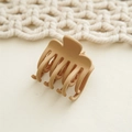Macro shot of small matte khaki hair claw clip with multi-tooth design on a woven fabric base - Khaki