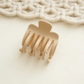 Close-up of matte beige shark hair claw clip with a minimalist bohemian style background - Beige