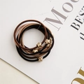 Detailed close-up of elastic hair ties featuring matte gold star pendants in neutral tones - Star Style / Earth Tone Combo