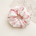 Close-up of a floral scrunchie with pink rose patterns on light chiffon fabric - Pink Petals