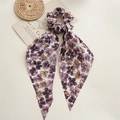 Dettaglio di un elastico in chiffon floreale viola con nastro lungo su sfondo vintage chic - Nastro Viola Petalo