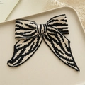 Eleganter Strick-Haarclip mit Schleife und klassischem schwarz-weißem Zebramuster - Gestrickte Schwarze Streifen Schleife