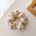Dettaglio dell'elastico per capelli floreale in poliestere con fiori gialli e lilla su beige - Floreale Blu