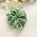 Close-up of elegant green satin hair scrunchie with soft pleated texture and silk sheen - Nylon Green