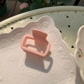 Minimalist square hollow hair claw clip in matte light pink finish on white ceramic plate - Light Pink