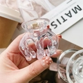 Close-up of a minimalist transparent acrylic hair claw clip held by hand with a gold spring - 5cm Transparent