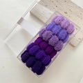 Dettaglio di sei elastici per capelli viola senza cuciture in una scatola trasparente - Serie Viola