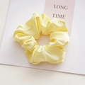 Close-up of elegant light yellow satin scrunchie with soft sheen and smooth texture - Solid Yellow