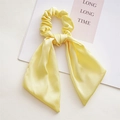 Close-up of elegant pale yellow satin hair scrunchie with long ribbon streamers - Knotted Yellow
