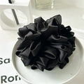 Dettaglio di un grande fermaglio per capelli a rosa in raso nero su vassoio di ceramica - Nero