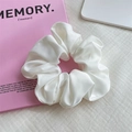 Coletero elegante de satén blanco con textura plisada sobre un libro rosa de adorno - Blanco