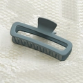 Detailed macro view of matte navy blue shark hair claw clip on white honeycomb texture - Cream Dark Green