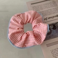 Dettaglio dell'elastico per capelli a quadretti rosa e bordo blu su sfondo estetico - Elastico Gingham Rosa