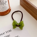 Detailed macro view of a light green marble-textured resin bow hair tie with brown elastic - Green Bow