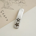 Close-up of a silver textured hair clip featuring vintage-style dual pentagram star accents - Thin Hollow Star Hair Clip
