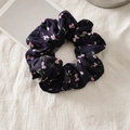 Nahaufnahme von Chiffon-Haargummi mit rosa Blumen auf tiefviolettem Stoff - Kleine Blume Marineblau
