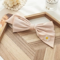 Close-up of a chiffon bow hair clip featuring delicate white daisy embroidery detail - Champagne Embroidery