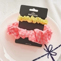 Detail of 2-piece hair scrunchie set in yellow and pink plaid on a ceramic display plate - Japanese Yellow