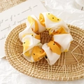 Dettaglio dell'elastico scrunchie in tessuto giallo con stampa frutta nel cesto - Bianco Sporco Pera