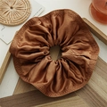 Brown satin oversized ruffled scrunchie with layered pleats on a wooden tray - Brown