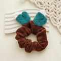 Détail du chouchou marron en peluche avec décoration de gant mignon et texture douce - Chouchou marron