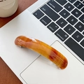 Nahaufnahme der eleganten Bernstein-Acetat-Haarklammer auf einem modernen Laptop - Verschmiertes Braun
