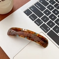 Nahaufnahme einer Haarspange mit Schildpattmuster auf einer silbernen Laptop-Tastatur - Bernstein