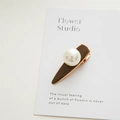 Detailed macro view of a brown glaze hair clip featuring a large pearl and rose gold alloy - Pearl Coffee