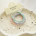 Detalle de gomas de pelo de alta elasticidad en colores Morandi y textura en espiral - Estilo de Textura Minimalista