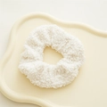 Dettaglio macro dell'elastico in pile teddy bianco su un vassoio decorativo a onde - Velluto Teddy Bianco