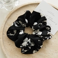 Dettaglio della trama del tessuto dell'elastico scrunchie con stampa floreale a inchiostro - Rosa Nero
