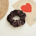 Détail d'un chouchou en velours marron foncé montrant la texture plissée et l'aspect soyeux - Café Foncé