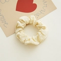 Detailed view of beige pleated fabric scrunchie with high elasticity and soft texture - Light Yellow