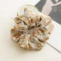 Detail eines Vintage-Blumen-Scrunchies mit Monet-Ölgemälde-Textur und Stofffalten - Kaffee Farbverlauf