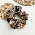 Détail du chouchou en tissu avec imprimé chat porte-bonheur et caractères sur coton beige - Chat Kaki