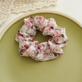 Detalle de coletero floral con estampado de rosas en un plato de cerámica con encaje - Estilo Floral de Rosas Rosa