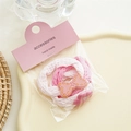 Close-up of pink and white knit hair ties with cute bow and paw charms in packaging - Pink Series