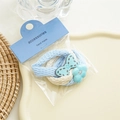 Close-up of sky blue and beige elastic hair ties with polka dot bow and smiley cloud charm - Blue Series