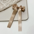 Close-up of champagne satin triple bow hair clip with long ribbons on a white tray - Khaki